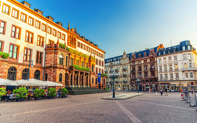 Historischer Platz mit alten Gebäuden bei klarem Himmel.