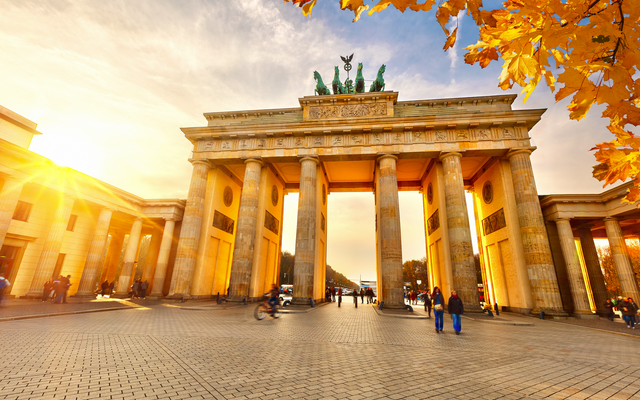 Brandenburger Tor bei Sonnenuntergang mit Herbstlaub im Vordergrund