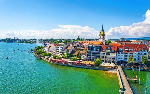 Küstenstadt am Bodensee mit Kirche und Häusern am Wasser.
