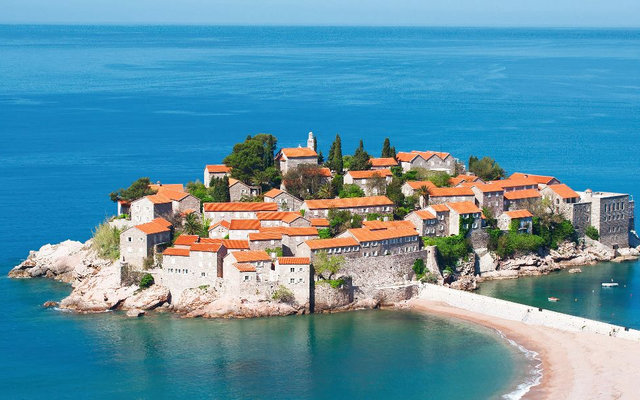Hotelinsel Sveti Stefan mit historischen Gebäuden und Meer in Montenegro.