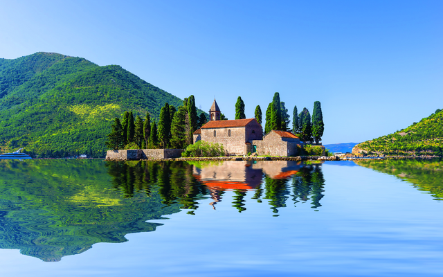 Insel Sveti Đorđe in der Bucht von Kotor in Montenegro, umgeben von Bergen und Wasser.