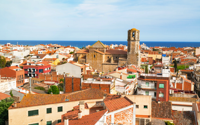 Stadtpanorama mit Kirche und Meer im Hintergrund.