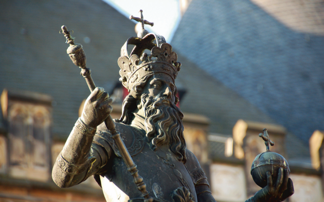 Statue eines gekrönten Herrschers mit Szepter und Reichsapfel.