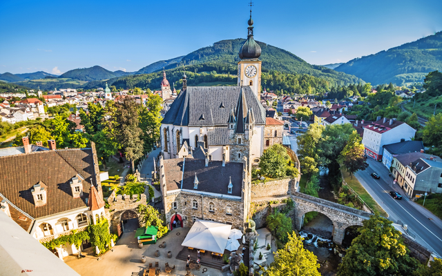Historische Kirche und Berglandschaft bei klarem Himmel.