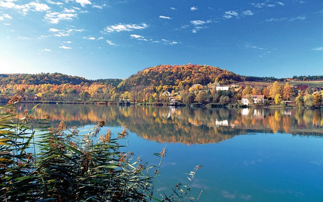 Panorama der Gemeinde Orfü am Pecser See mit Herbstbäumen und klarem Himmel.