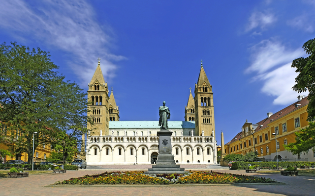 Eine Kathedrale mit zwei Türmen und einer Statue im Vordergrund.