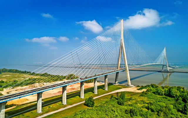 Große Schrägseilbrücke über einem Fluss mit blauem Himmel im Hintergrund.