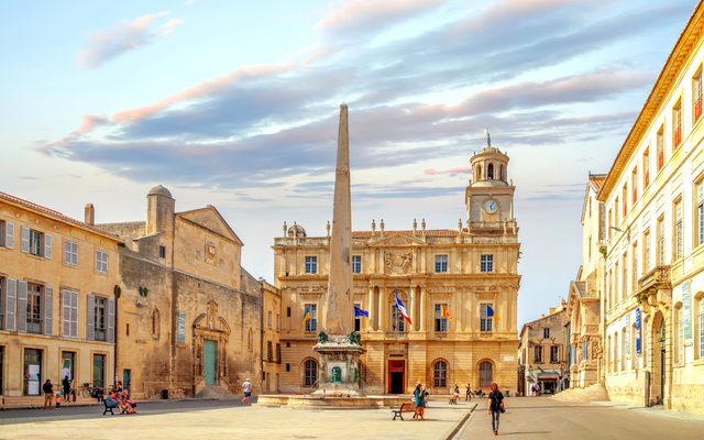 Historischer Platz mit Obelisk und alten Gebäuden bei Sonnenuntergang.